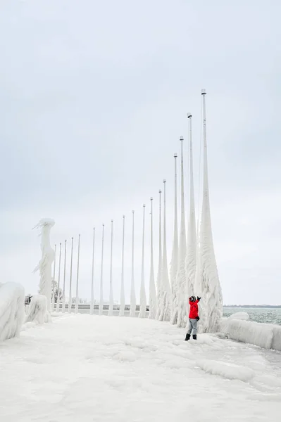 Child Red Coat Touching Icy Flagpoles Frozen Pier Winter — Φωτογραφία Αρχείου
