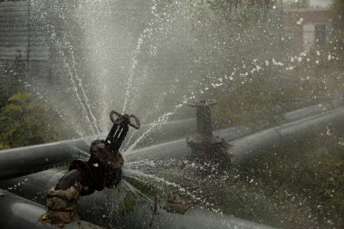 Valve on tube. Torn pipe valve. Boiling water pours from pipeline. Sewer breakout.