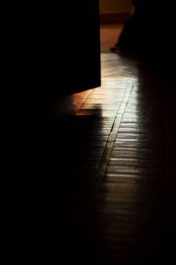 Light on parquet in room. Light from window in dark apartment. Reflection on floor. Wooden parquet in light.