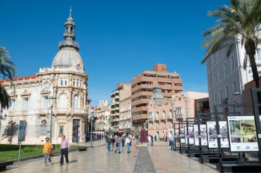 Cartagena, Spain : 2022 November 23 : People walking in the touristic city of Cartagena with boats moored in the autumn of 2022.