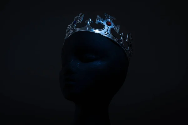 Bright crown  on black head on black background