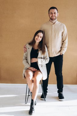 man and a pregnant woman waiting for a child hug at home