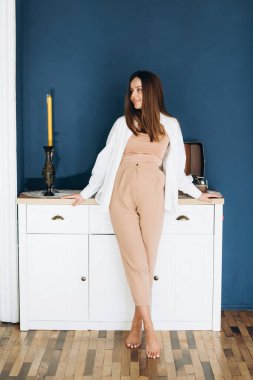 young pregnant blonde on the background of a white wall