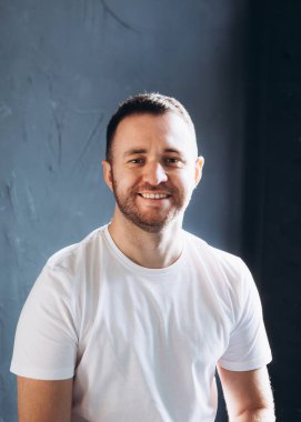 portrait of a handsome young man with beard on a gray background