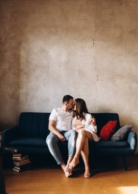 man and a pregnant woman waiting for a child hug at home