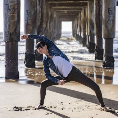 A woman doing stretching exercises outdoors.