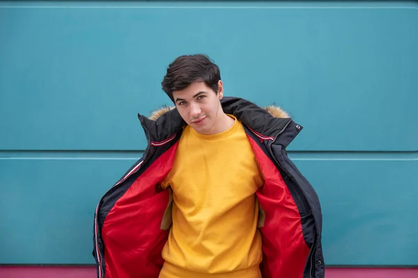 Młody Mężczyzna Żółtym Swetrze Czerwonej Kurtce Niebieskim Tle — Zdjęcie stockowe