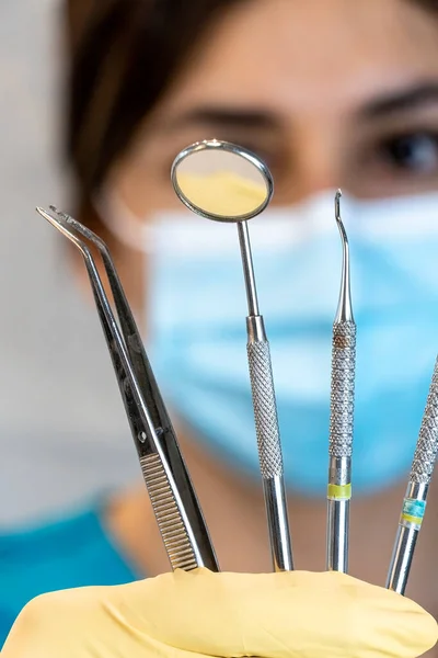 young female dentist holding dental instruments in her hand
