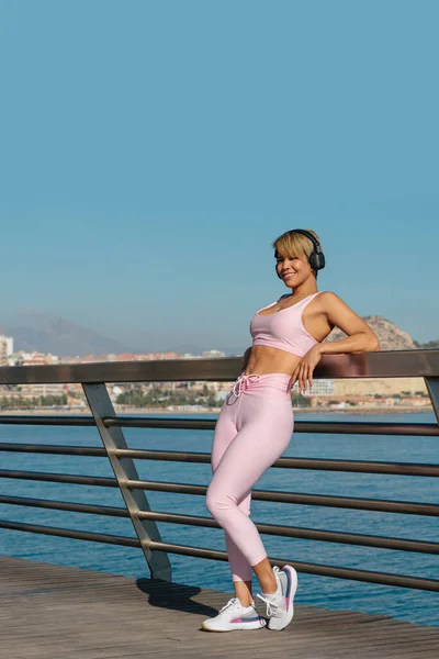 Latin beautiful woman does fitness outdoors near the beach. sport concept