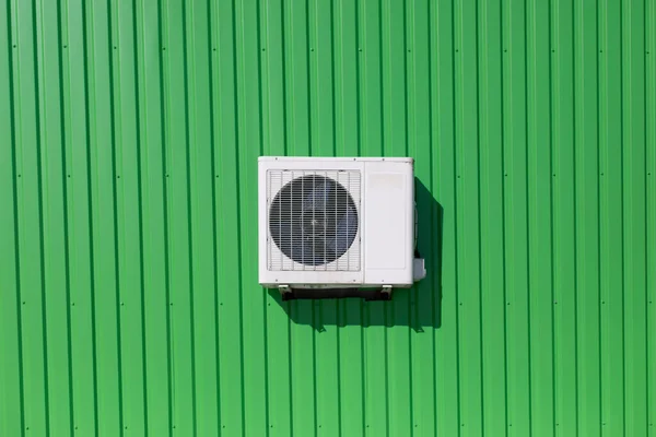 Air conditioning on wall. Cooling equipment. Green wall of industrial building. Square air conditioning.