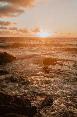 Sunrise in hawaii on the rocks clipart