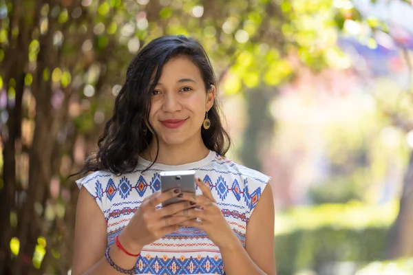 Real Mexican Woman Holding Smart Phone Looking Camera Outdoors — Stockfoto