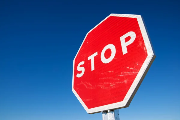 Stop traffic sign with cloudless sky.