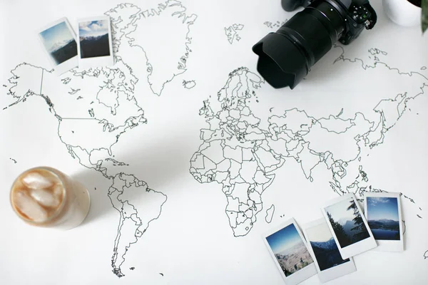 Polaroid Photos on World Map with Ice coffee and Camera