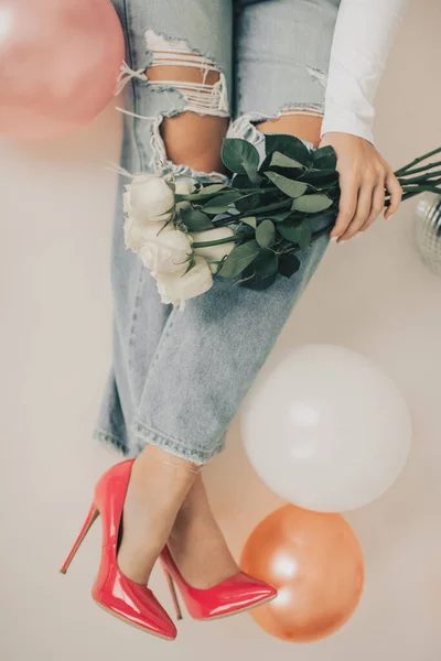 Over Head Photo of Woman Wearing Pink Heels while holding flowers