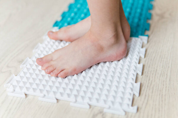 child's feet on a orthopedic mat
