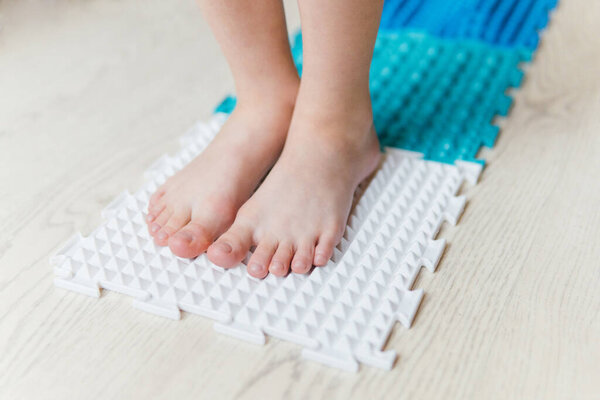 a boy walks on an orthopedic rug