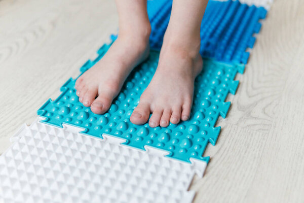 a boy walks on an orthopedic rug