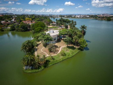Belo Horizonte, Minas Gerais, Brezilya 'daki yeşil alanda göl kenarındaki modern müze binasına güzel drone manzarası