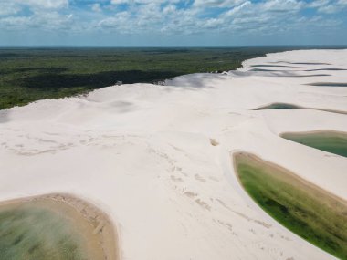 Beautiful aerial view to white sand dunes and green rainwater pools in Lenis Maranhenses, near Barreirinhas, Maranho, Brazil 