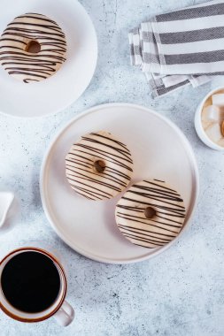 coffee donuts in light glaze and coffee with a cup