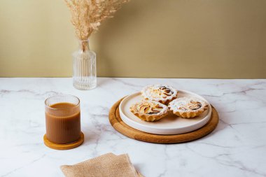 dessert on a plate and coffee with milk in a glass.
