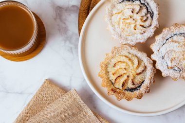 dessert on a plate and coffee with milk in a glass.