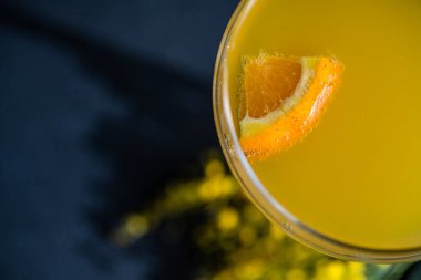 Mimosa cocktail in the glass on black stone table