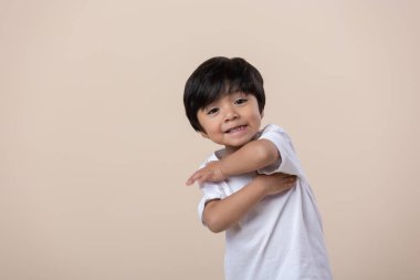 Mexican little boy sitting on the floor, looking at camera