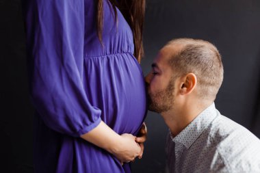 man is happy with the white belly of his pregnant wife