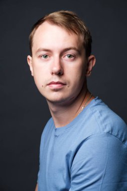 Portrait of young confident blond man in studio