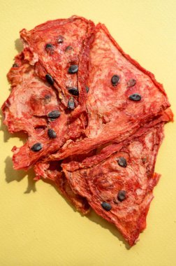 watermelon chips with pit on yellow background