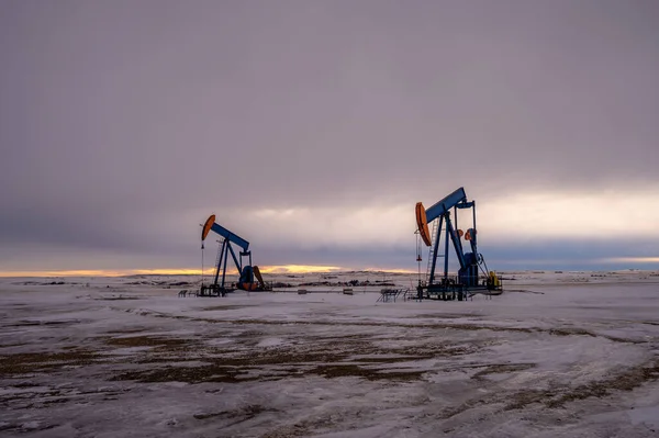 冬には気分の良いアルバータ州の朝に地下から原油を汲み上げるポンプジャック — ストック写真