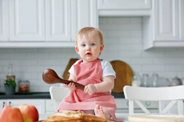 kid in the kitchen with a big spoon, copy space