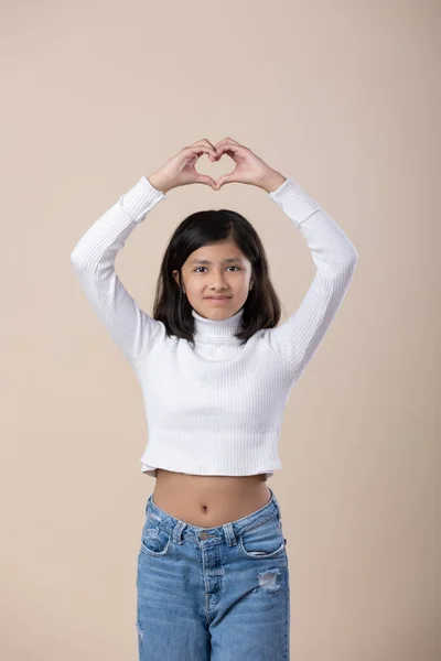 Mexican girl making heart shape with hands, children rights