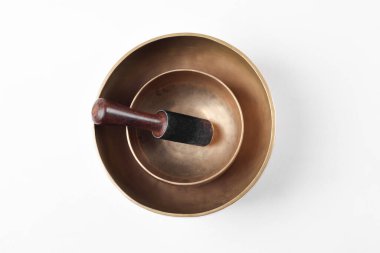 Tibetan singing bowls with stick for meditations on white background