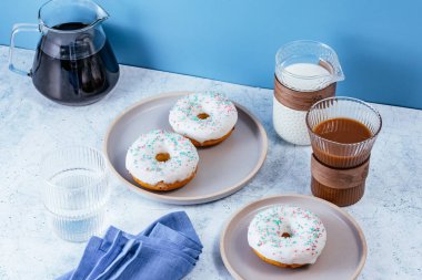Donuts in white glaze with colored sprinkles