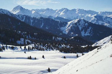 Landscape with a snowy valley surrounded by snow-capped mountains.