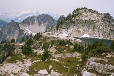 Pct boyunca ağaçlar ve granit kayalarla çevrili Alp Gölü.