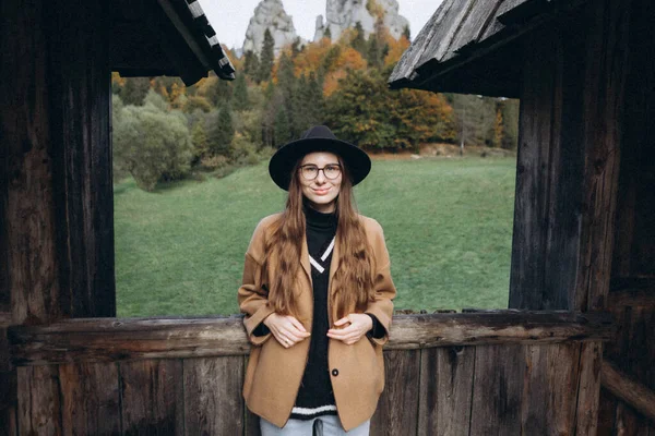 茶色のジャケットを着た若い女性と森の中の黒い帽子 — ストック写真