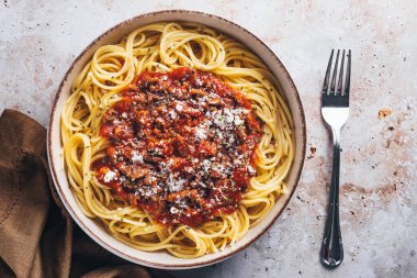 Flat lay view of spaghetti with bolognese sauce on stone background.