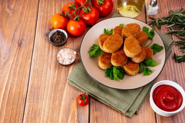 chicken nuggets on a plate with sauce, wooden countertop