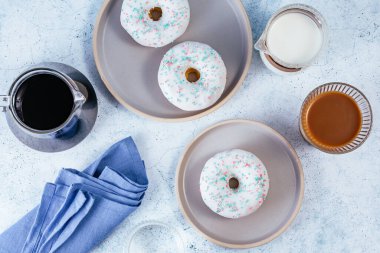 Donuts in white glaze with colored sprinkles