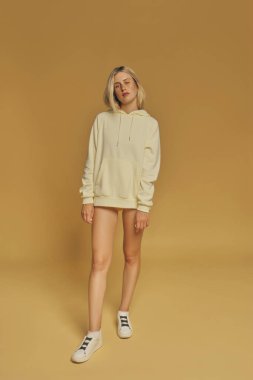 Young freckles woman wearing a yellow sweatshirt