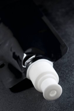 Flexible plastic bottle on a black table.