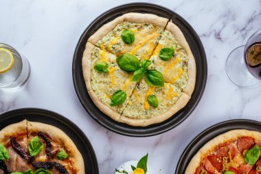 pizza four cheeses on a marble table