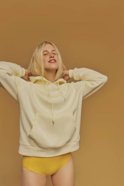 Young freckles woman wearing a yellow sweatshirt