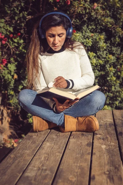 Latin Kadın Dışarıda Oturmuş Müzik Dinliyor Kitap Okuyor — Stok fotoğraf
