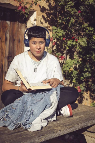 Giovane Studente Che Legge Ascolta Musica Seduta Giardino — Foto Stock