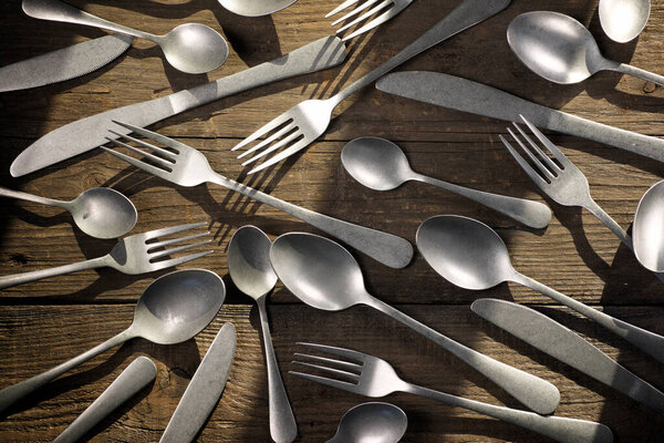 Металлические столовые приборы на деревянном столе